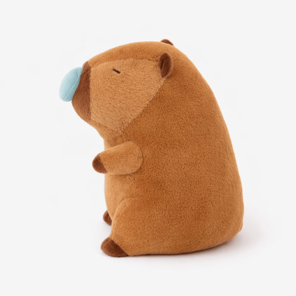 Pluschtierland Schlafendes Capybara Kuscheltier mit blauer Nasenblase Schlafendes Capybara Kuscheltier mit blauer Nasenblase